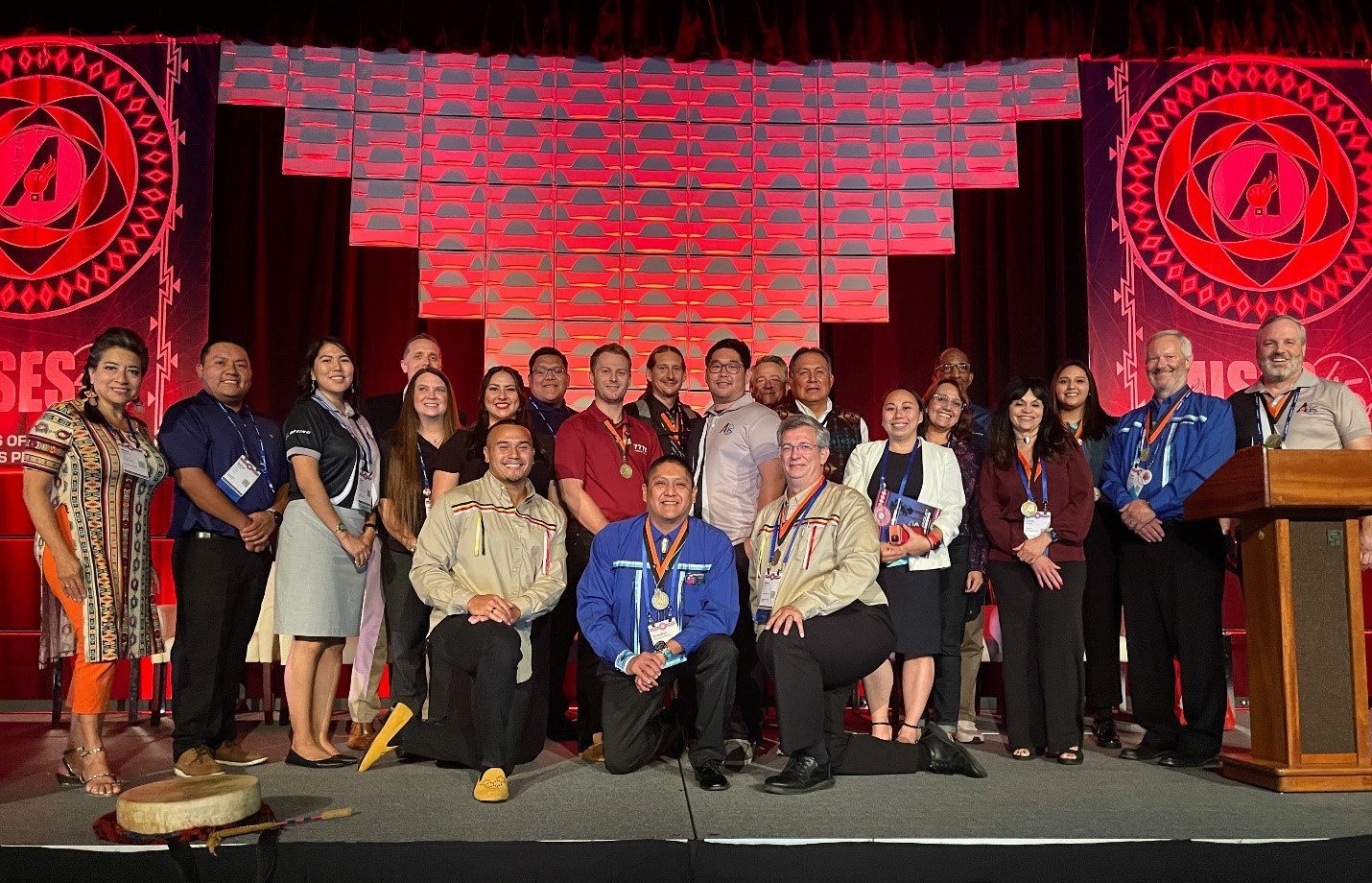 A group of Boeing employees are posing on stage at the American Indian Science & Engineering Society conference.